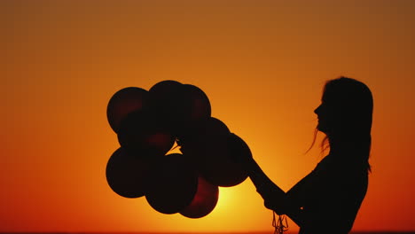 Silhouette-Einer-Frau-Mit-Luftballons-Bei-Sonnenuntergang-Inspiration-Und-Kreativitätskonzept