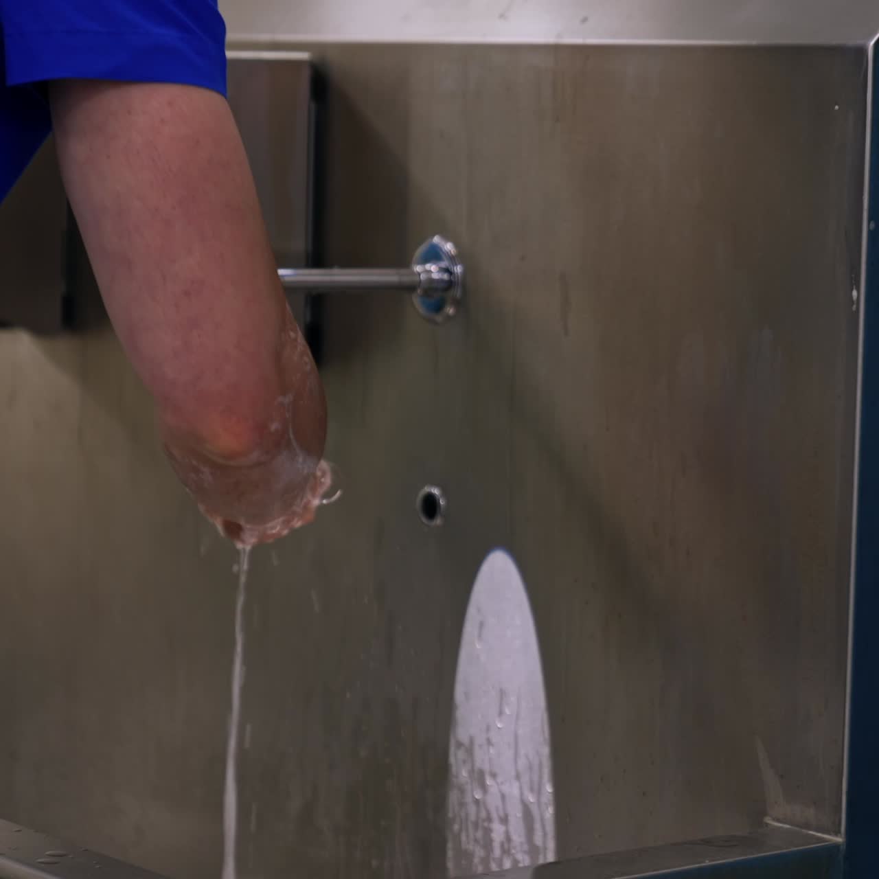 Male Caucasian doctor washing hands to the elbow. Neurosurgeon getting ready for operation
