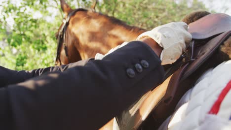 hombre afroamericano instalando la silla de montar el caballo de doma