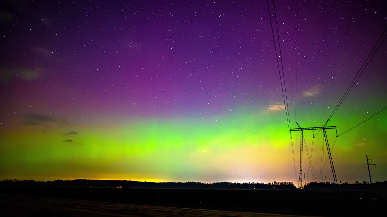 time-lapse toma de las luces del norte aurora boreal polar bailando sobre el poste eléctrico a lo largo del campo rural por la noche