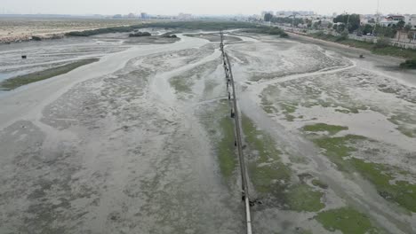 aerial flying over waterlogged area, irrigation pipes extending into green area