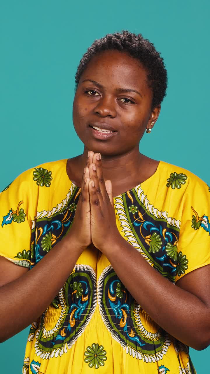 African Woman in Traditional Dress Making Namaste Gesture