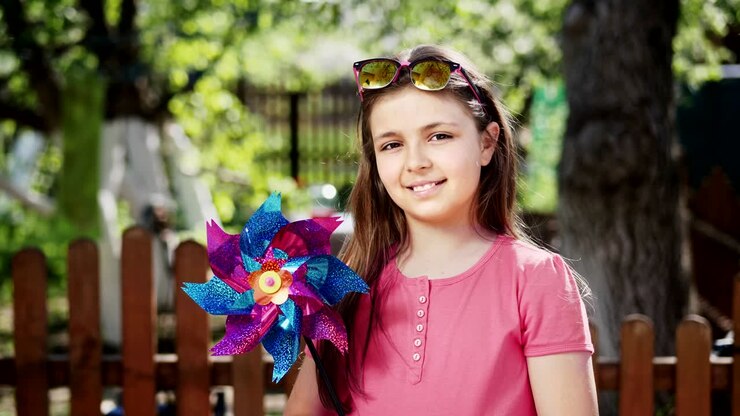 Niña preadolescente con un juguete de molino de viento