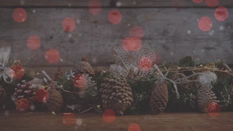 Animation-of-red-spots-of-light-over-christmas-decoration-with-pine-cones