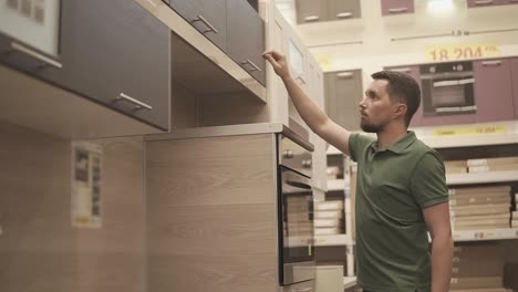 man looking at kitchen cabinets in a showroom