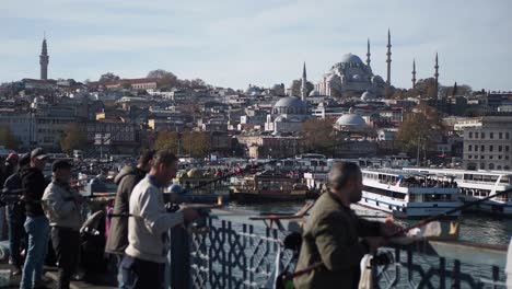 people fishing on a bridge in istanbul with the blue mosque in the background