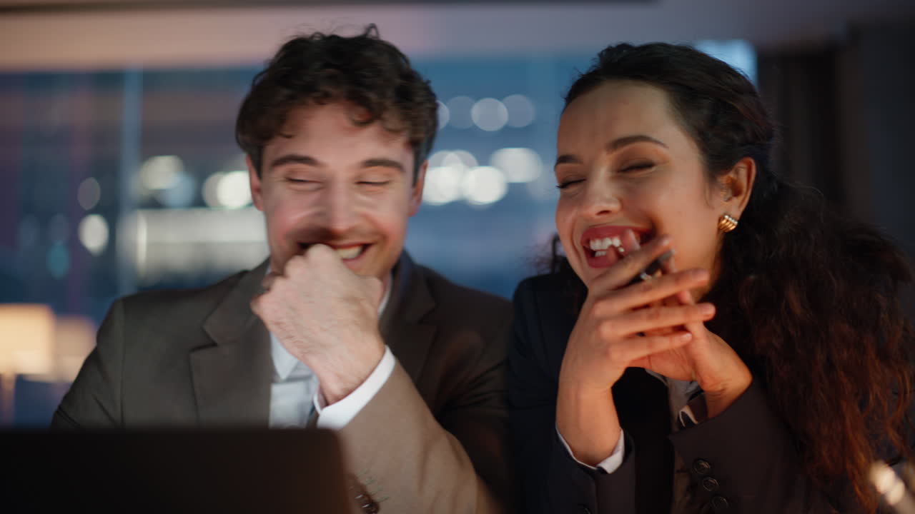 Evening office pair flirting at laptop workplace work at dark room portrait