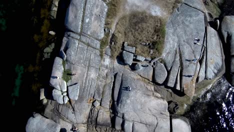 aerial birds eye view over granite rocks beside punta cabalo lighthouse on arousa