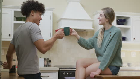 happy diverse couple smiling and drinking coffee at home