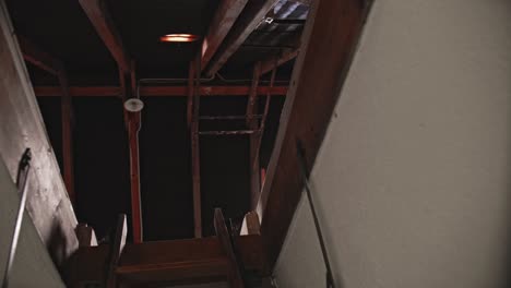 bottom view of an open roof hatch, seeing the rooflight and the old wooden beams of an ancient farmhouse