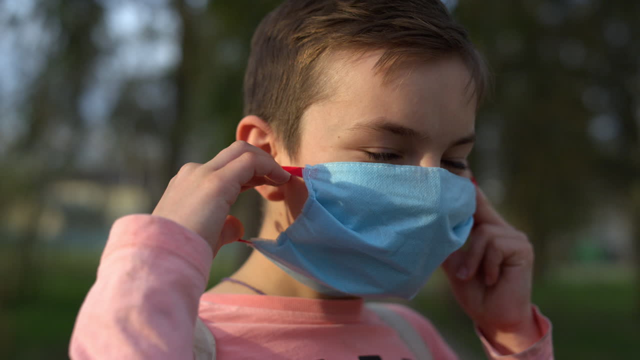 야외에서 카메라를 찾는 웃는 소년의 초상화. 가면을 쓴 아이가 카메라를 포즈하고 있다.