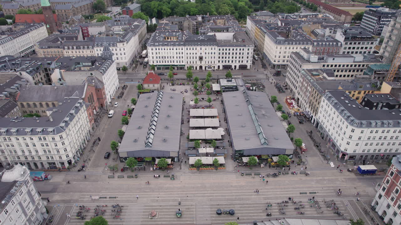 코펜하겐의 심장부에 있는 사람들과 자동차들로  ⁇ 비는 토르베할레네 (torvehallerne) 는 정오에 항공사진으로 포착됩니다.