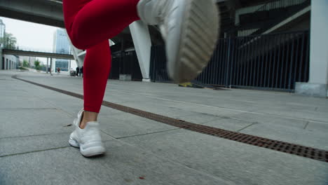 Close-up-female-runner-legs-jogging-on-urban-street.-Sporty-girl-training-run.