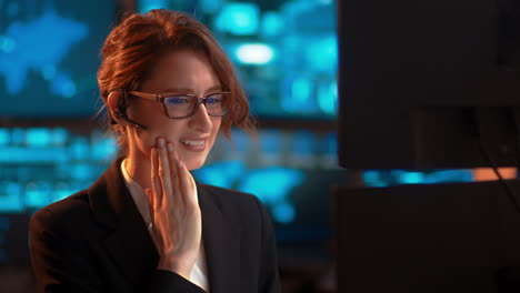 statis shot, a businesswoman at work talking through her bluetooth headset, in a customer service-type industry, experiencing major tooth pain