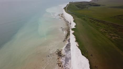 turistas caminando por el borde de los acantilados de tiza de seven sisters beachy head, antena