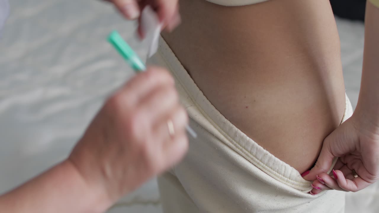 la enfermera hace una jeringa de inyección de antibióticos a los pacientes la inyección en el culo