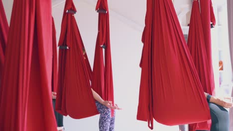 damas descalzas sentadas en hamacas con los ojos cerrados meditando