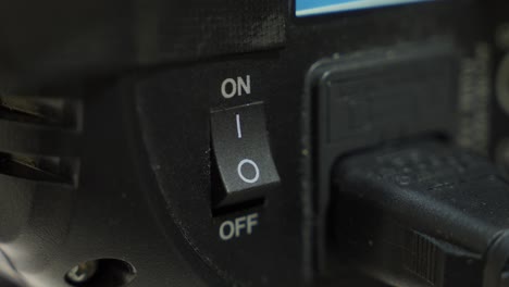 a finger switching a device from off to on, close-up shot