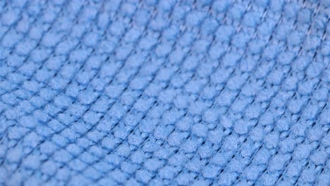 macro shot of the material of a blue dishcloth, macro shot close up detail view rotating motion