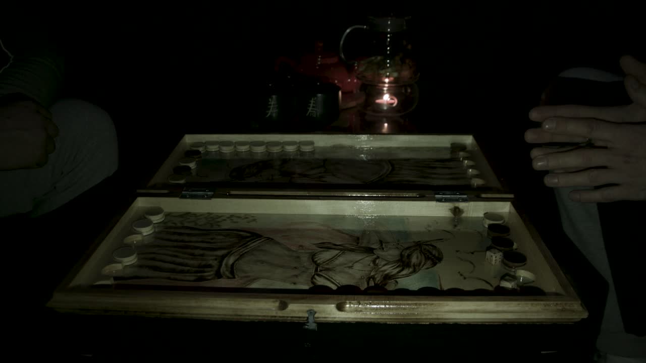 двое людей играют в настольную игру ночью