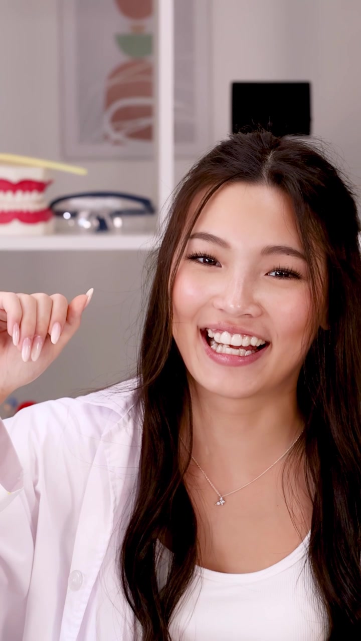 Friendly Female Dentist Waving at Camera in Dental Office