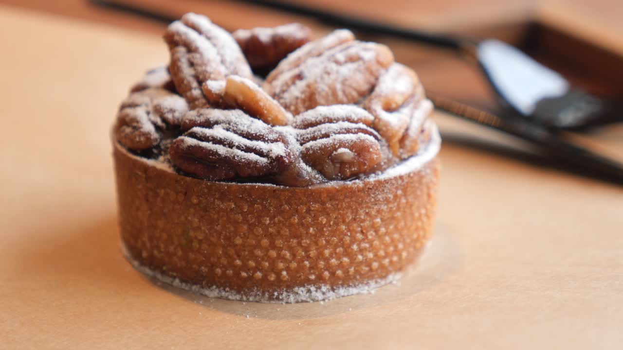 Primo piano di una deliziosa crostata alle noci pecan spolverata con zucchero a velo