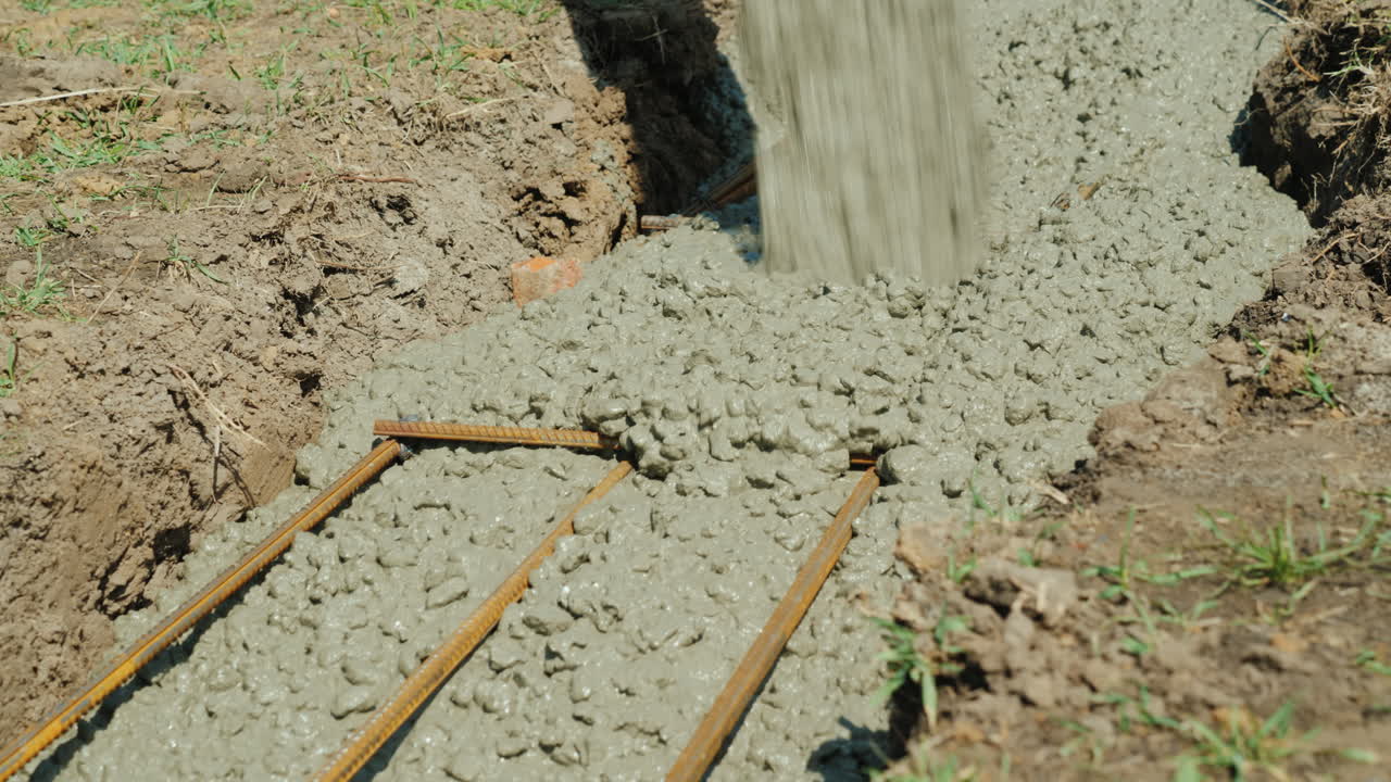 el hormigón fluye a través de la tubería hacia los cimientos del concepto de construcción de cabañas en el sótano