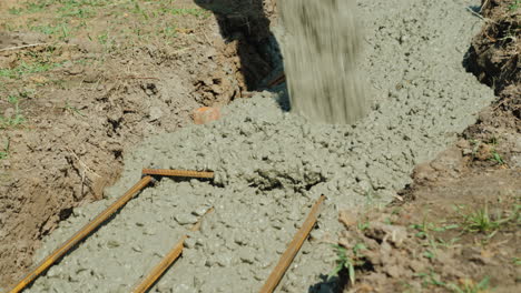 el hormigón fluye a través de la tubería hacia los cimientos del concepto de construcción de cabañas en el sótano