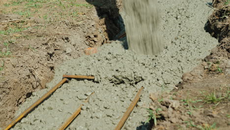 concrete flows through the pipe into the foundation of the basement construction of cottages concept