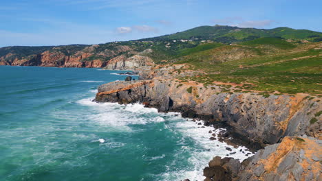 sunny beautiful seascape ocean waves splashing on rocky coast. aerial foamy sea