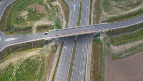 Vista-Aérea-De-Los-Coches-Que-Circulan-Por-Una-Carretera-Elevada-Sobre-Una-Carretera-Vacía