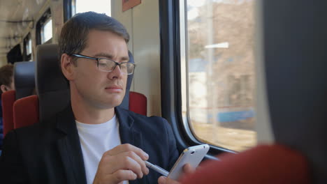 man with cell phone enjoying view from the train window