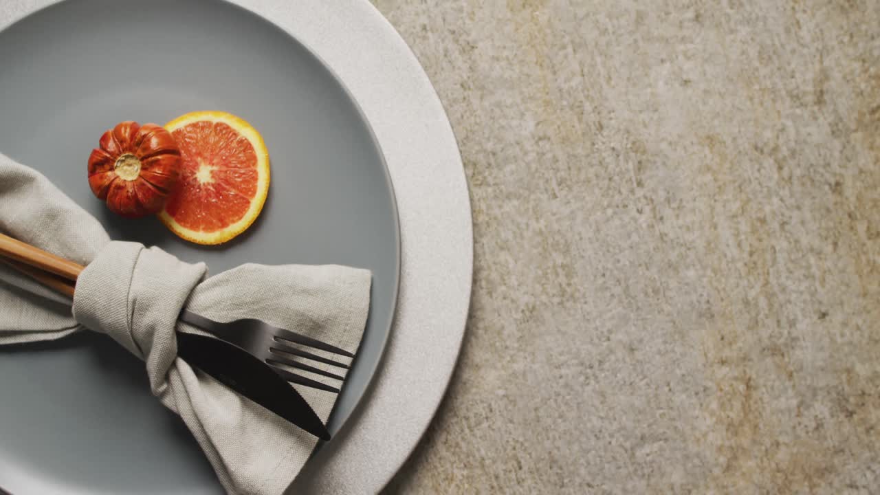 Video di piatto con decorazioni arancioni e autunnali appoggiato su una tovaglietta beige
