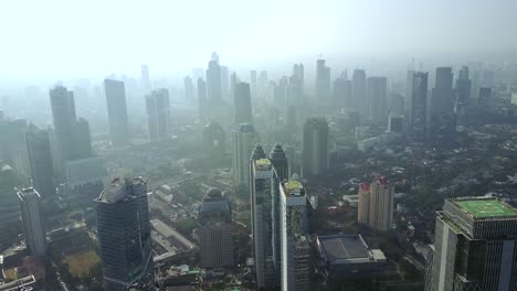 aerial view of skyscrapers in the jakarta city with smoke in the misty morning, shot in 4k resolution