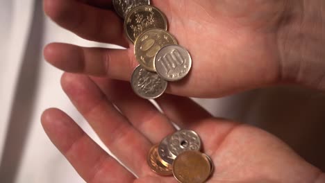 toma en cámara lenta de monedas y dinero de japón que se transfieren entre manos en un entorno de primer plano