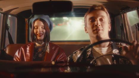 woman laughing and chatting with taxi driver in retro cab at night