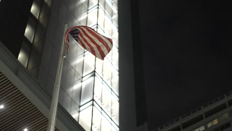 Flag-Flying-on-Pole-Outside-Four-Seasons-Hotel,-Philadelphia,-PA---Nighttime