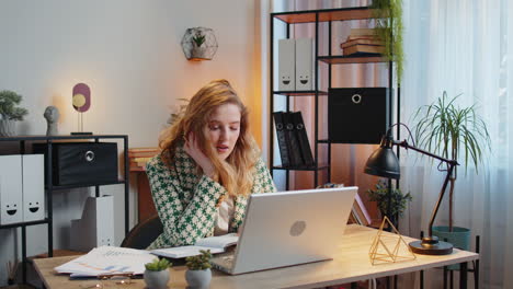 business woman writing down taking down notes while attending online video class meeting on laptop