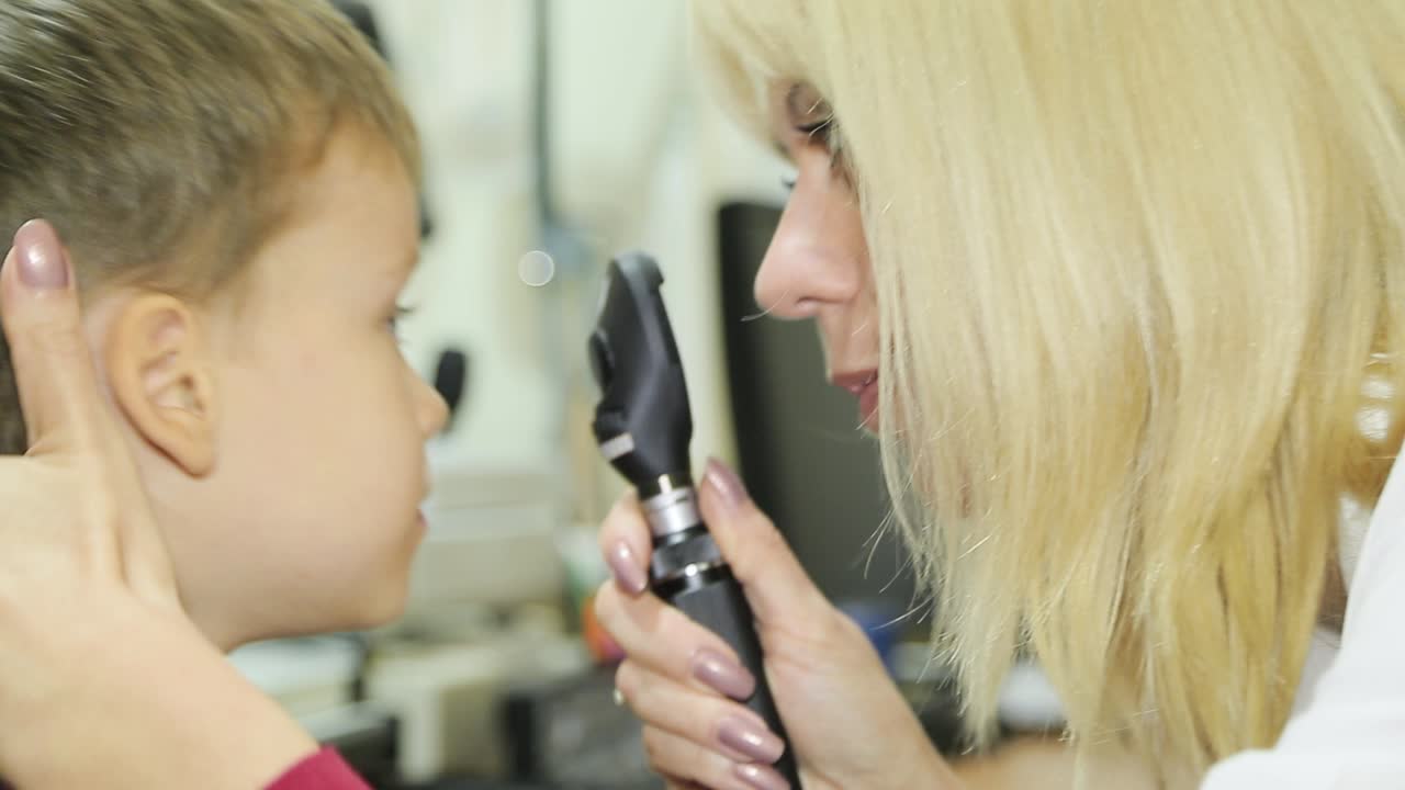 Professional ophthalmologist checks the eyesight of the child. Eye examination