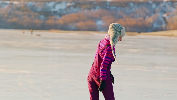 People ice skating on a frozen lake in winter