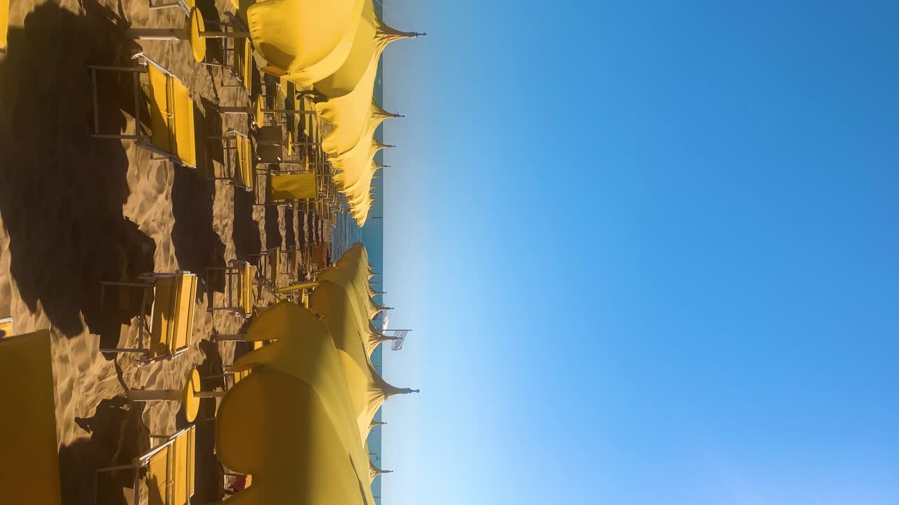Formato de video vertical con los colores de Ucrania, con sombrillas de playa amarillas azotadas por el viento y cielo azul de fondo para espacio de texto