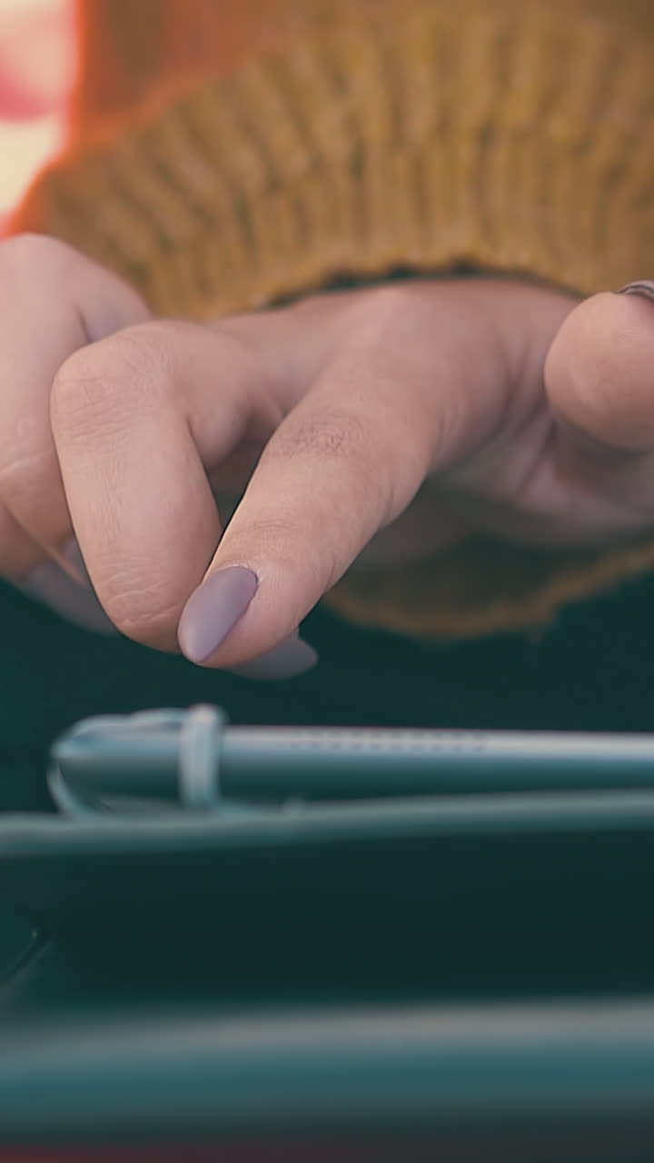 young woman uses modern tablet in tourist camp on meadow in early morning extreme close view slow motion