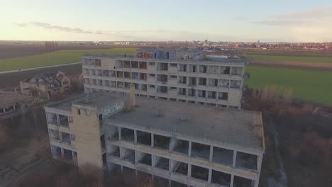 drone pulls back from an abandoned building with graffiti over it