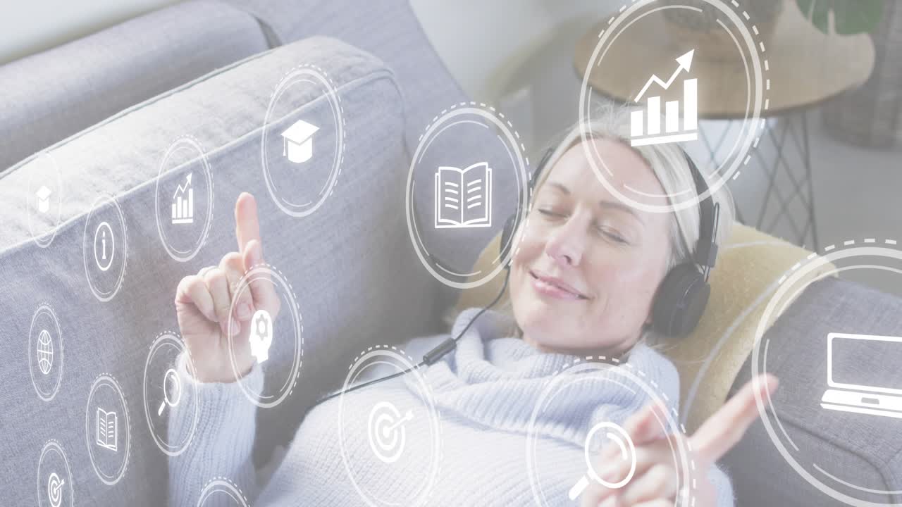 Woman reclining sofa viewing floating icons raising fingers tapping symbols exploring tech insights