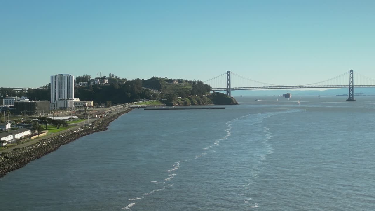 Pan drone shot of Treasure Island and San Francisco-Oakland Bay Bridge with sunny weather in California, USA
