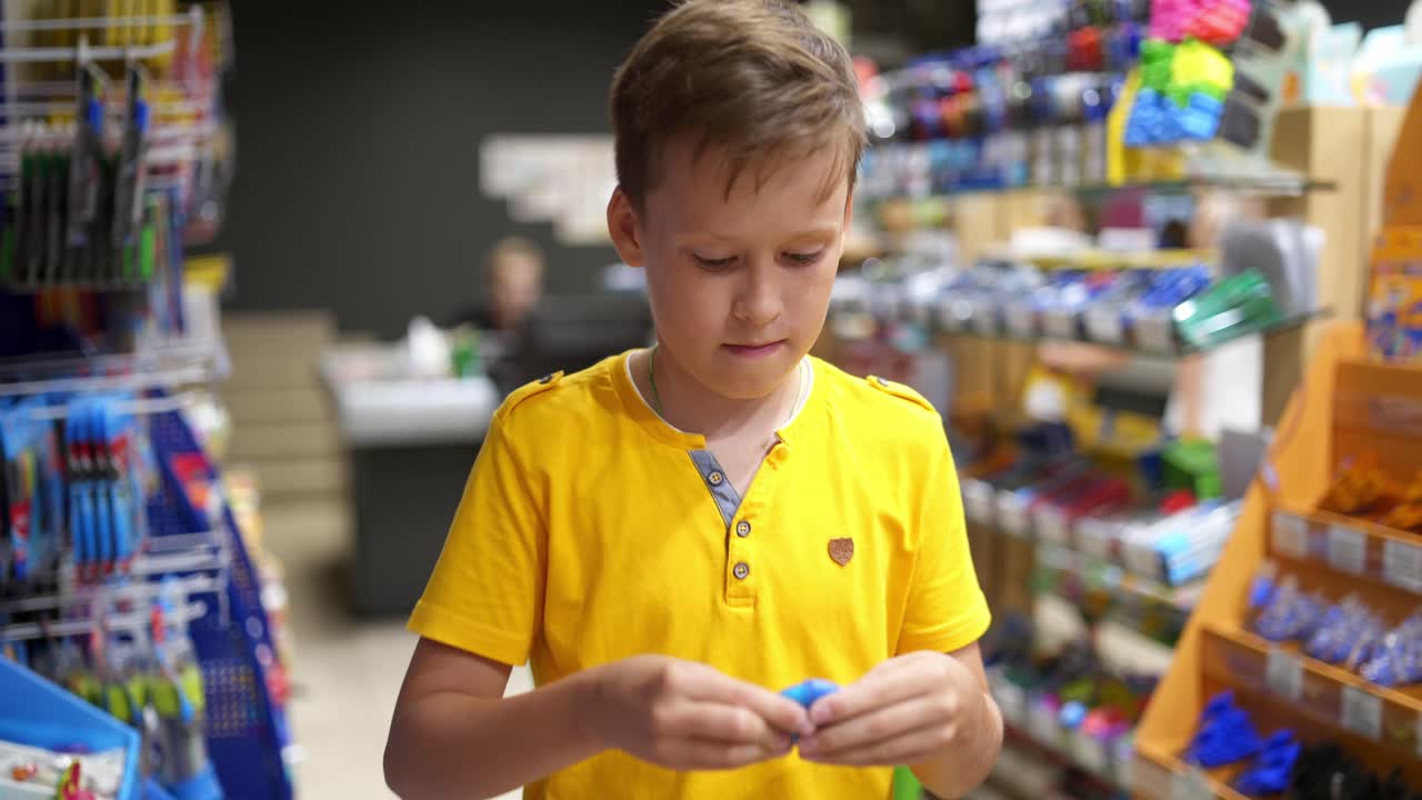 Back to school concept. Boy near shelves with school stationery in store