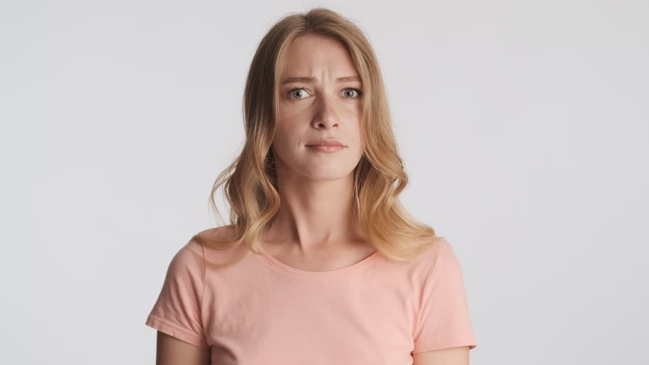 una mujer caucásica saludando no con la cabeza en la cámara.