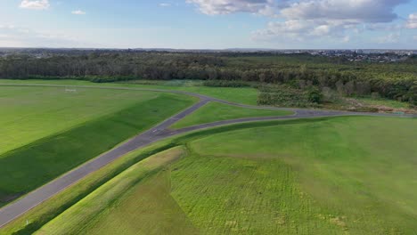 aerial view of expansive green fields and pathways under clear skies at gold coast, australia, captured by a drone