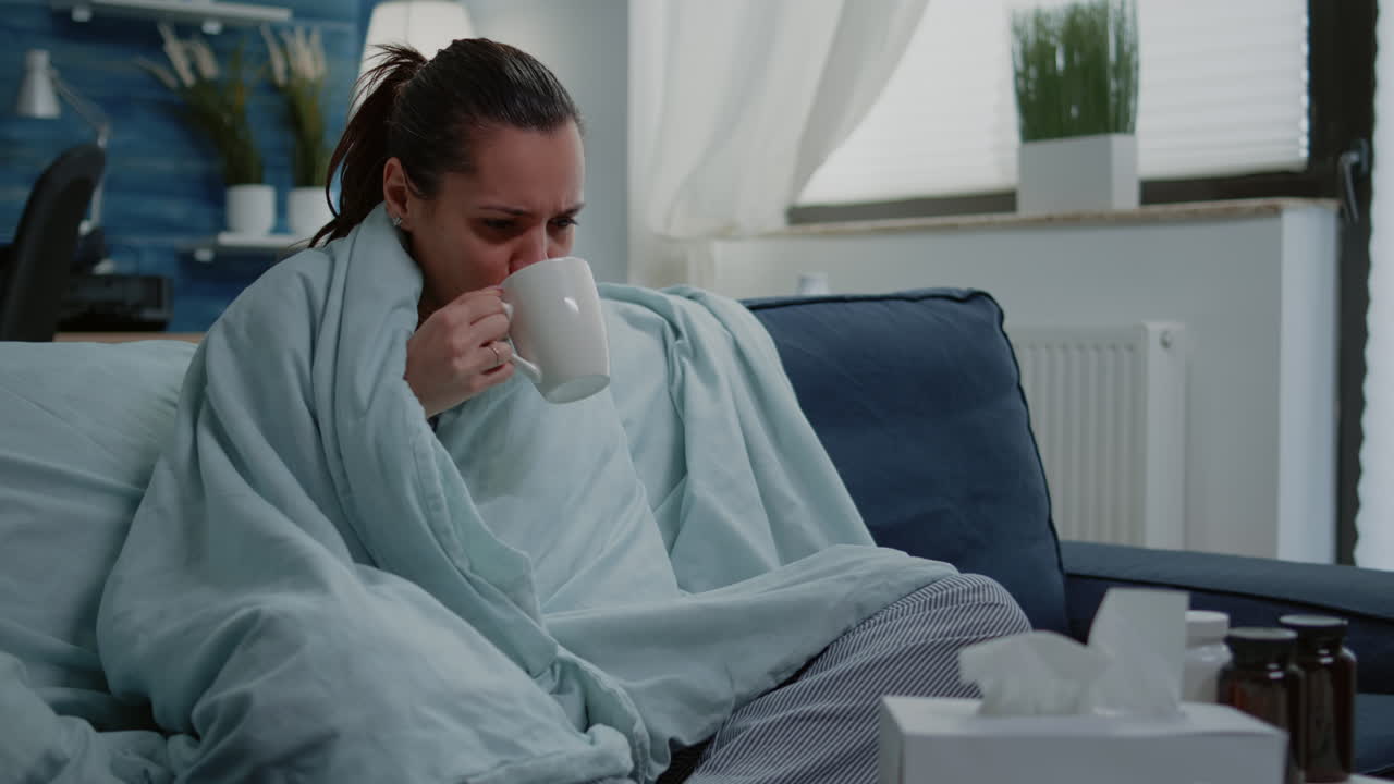 Sick woman using tissue to blow runny nose having cold