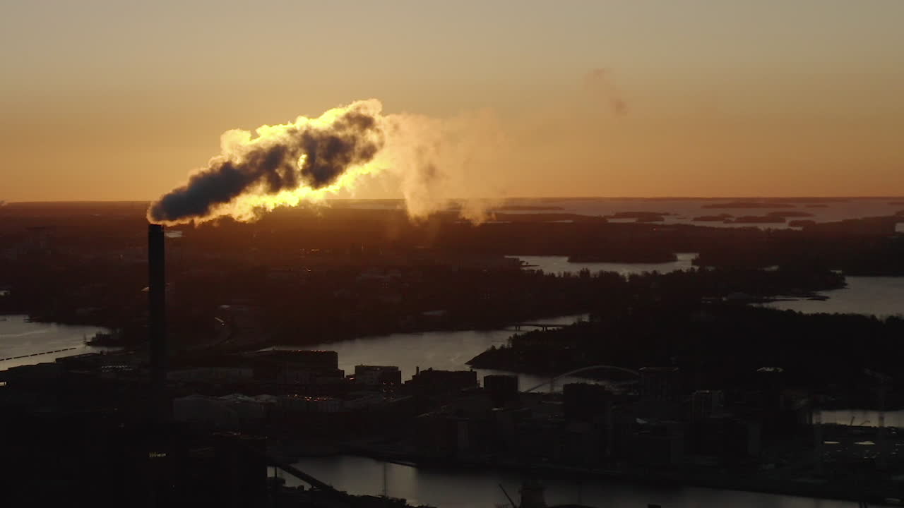 Industrial chimney exhaust smoke and steam. Air Pollution. Sunset